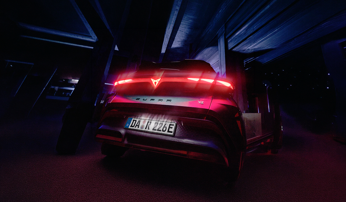 CUPRA Raval in Fahrt, von oben fotografiert auf nasser Fahrbahn - Panoramadach und dynamische Silhouette des Elektro-Crossovers gut erkennbar.